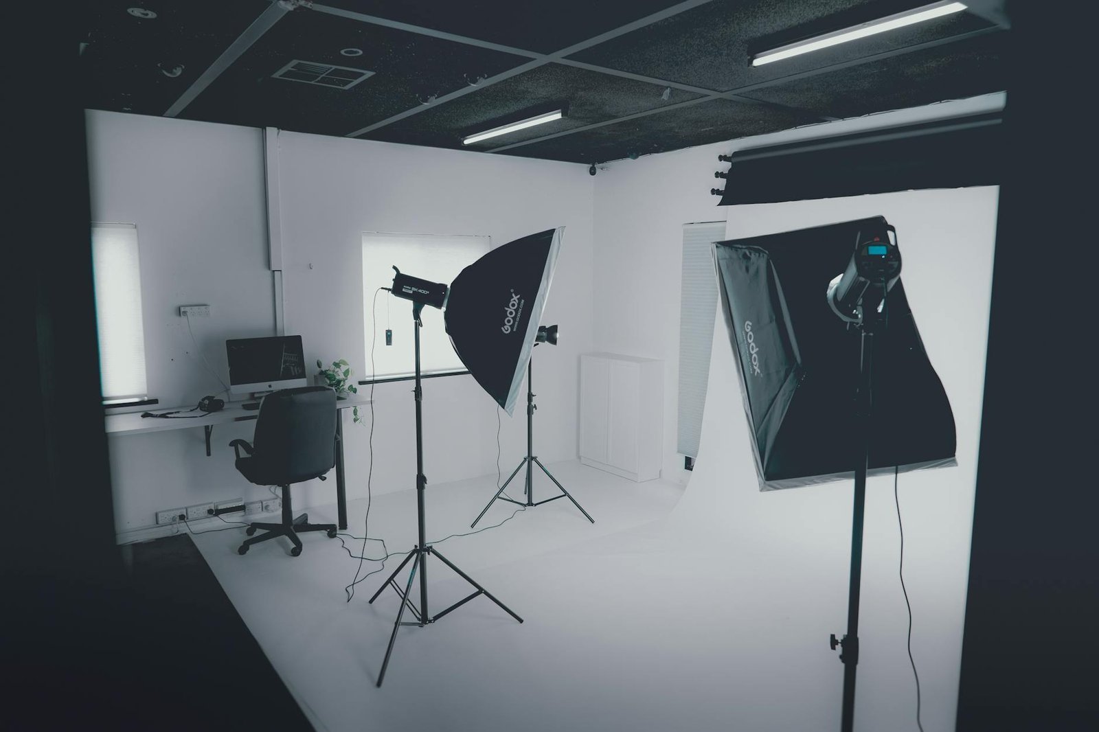 Studio photo professionnel équipé de softbox sur pieds et de fond blanc