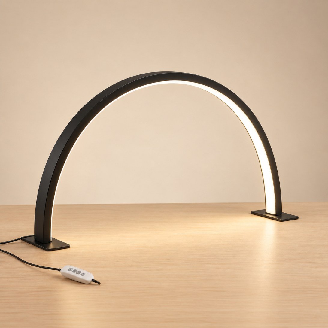 Lampe demi-lune de table noire, allumée, posée sur ses deux pieds plats, avec son boîtier de commande sur le câble