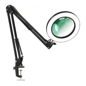 Lampe loupe LED noire à bras articulé, allumée, avec sa pince de fixation au bord de la table
